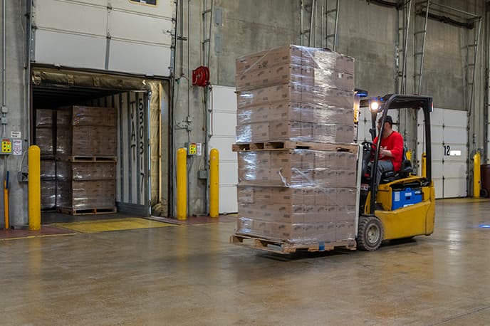 Employee moving packages with forklift